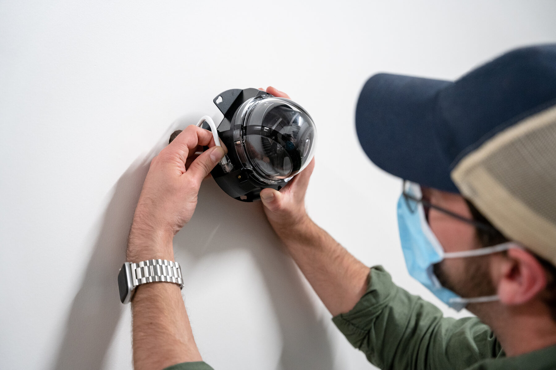 Two engineers fitting a dome camera to a ceiling