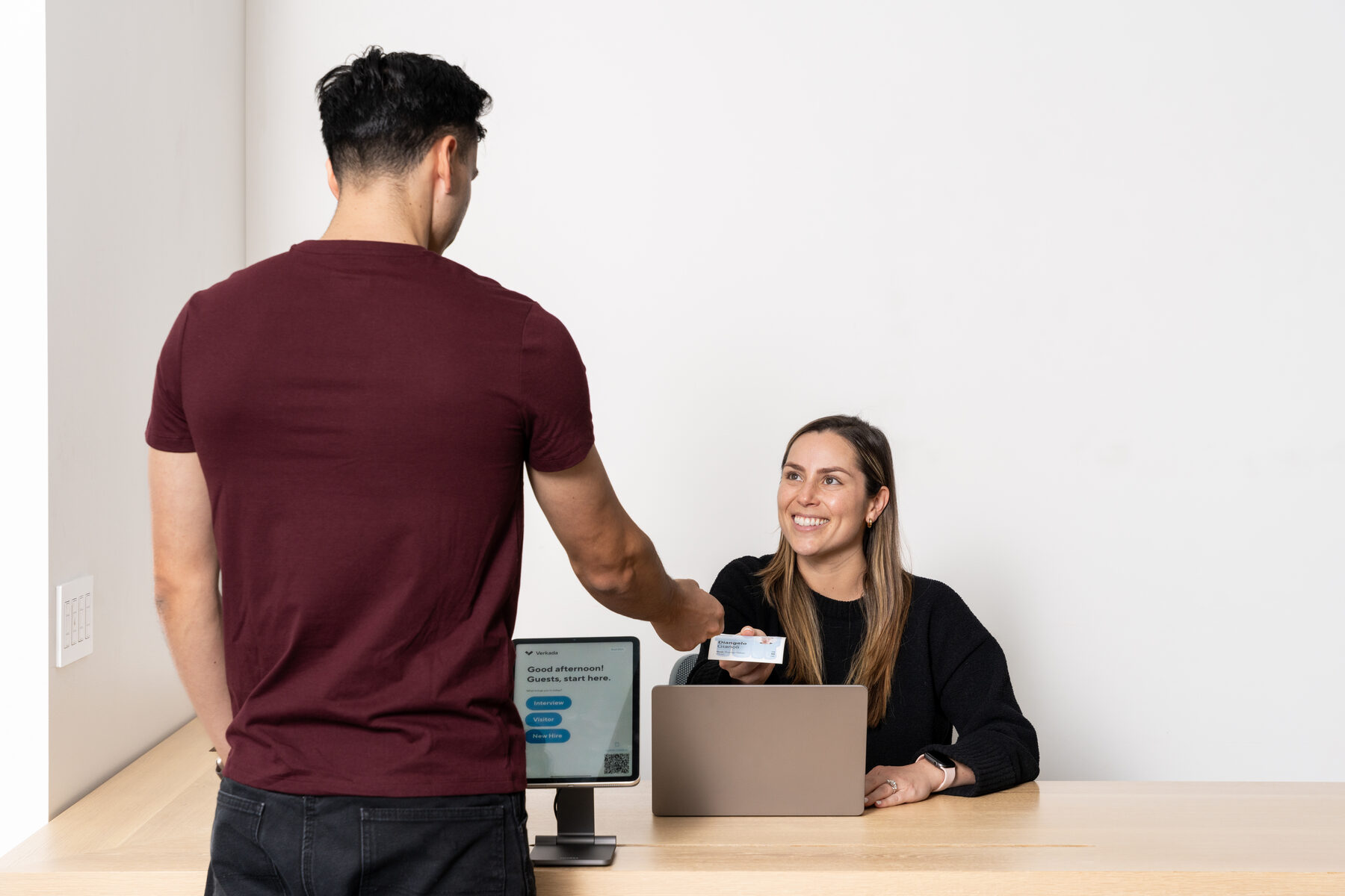 A visitor signing in at a reception desk